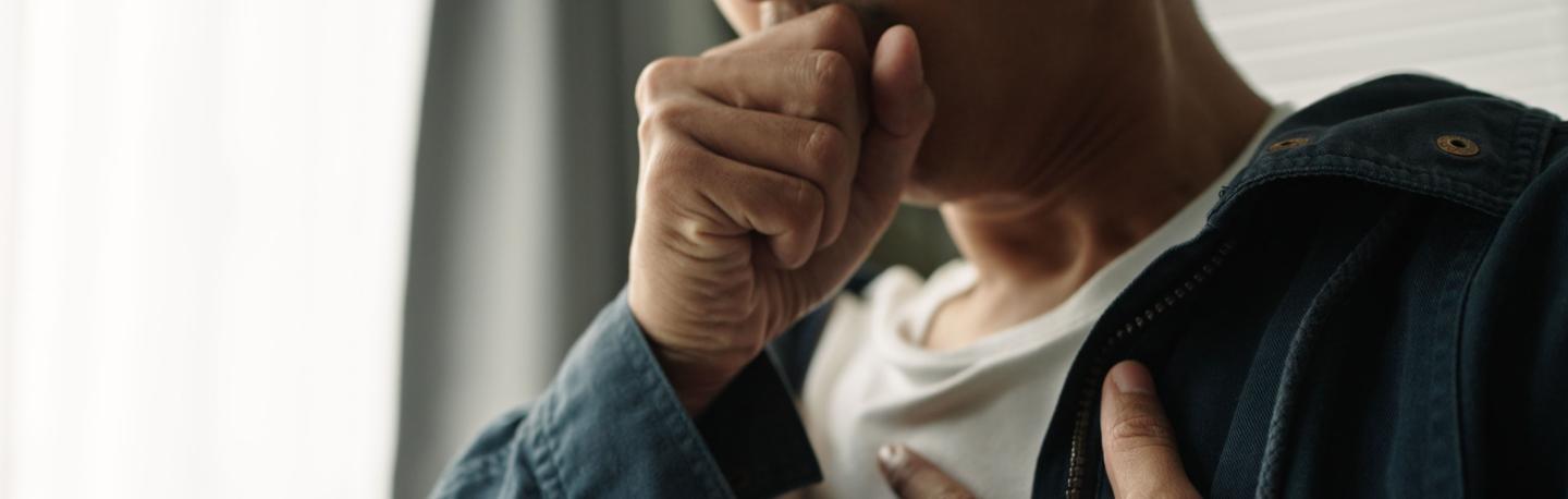 Person coughing and covering chest